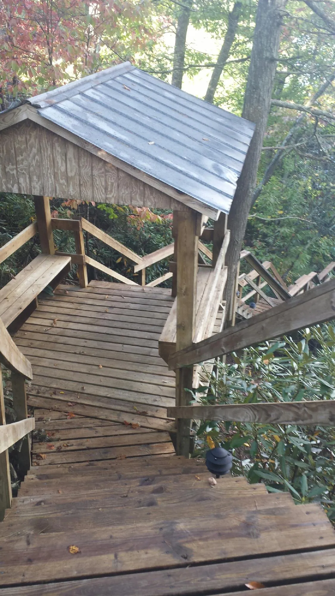 Metal roofed shelter over wooden steps on a wooded walkway — Skylight Repair & Installation work by our crew in Deerfield