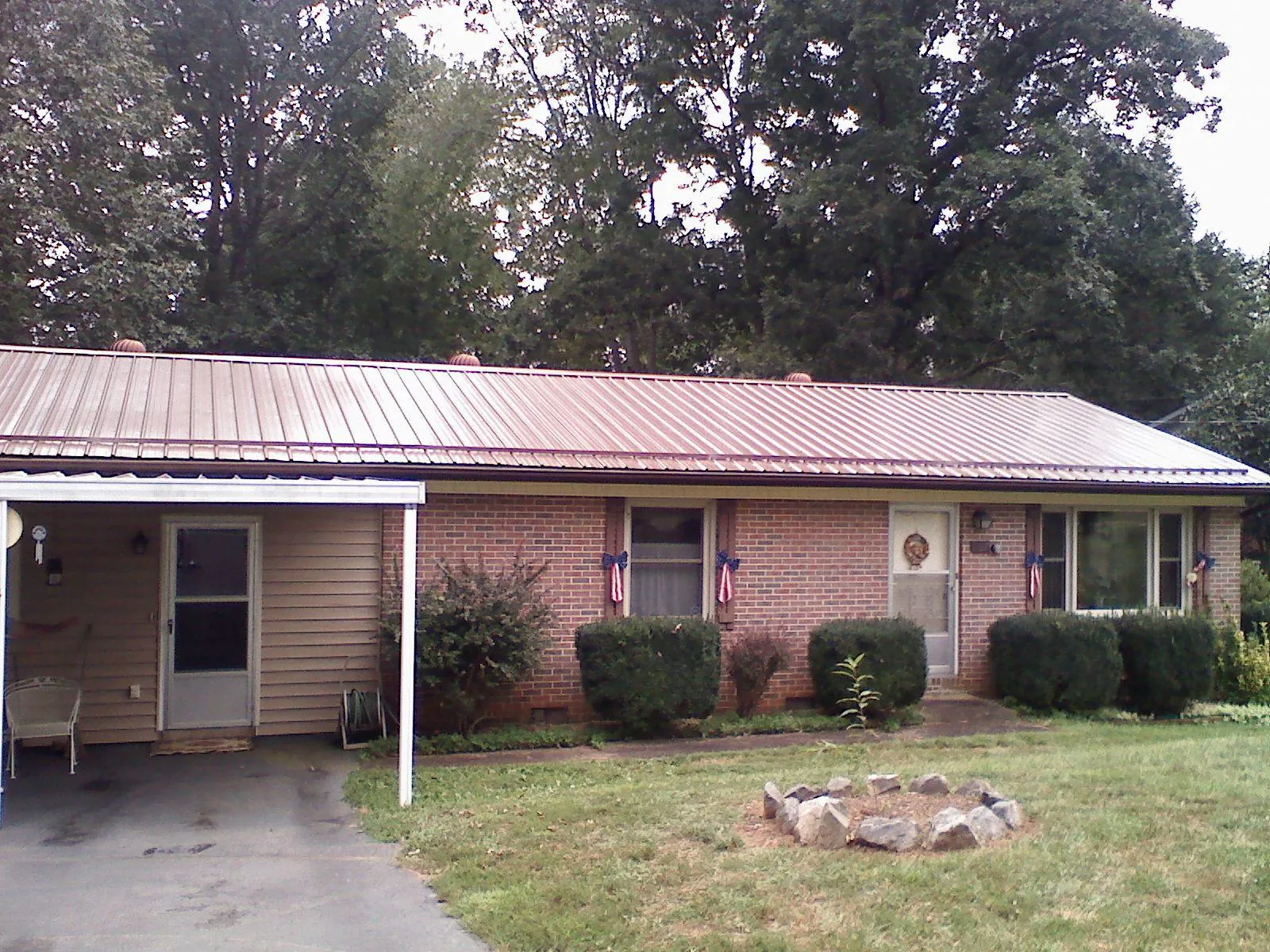 Bronze metal roof and carport on a brick ranch home — Roof Repair work by our crew in Deerfield